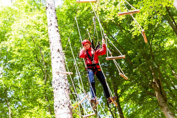 Photograph of a young girl taking part in a high ropes course