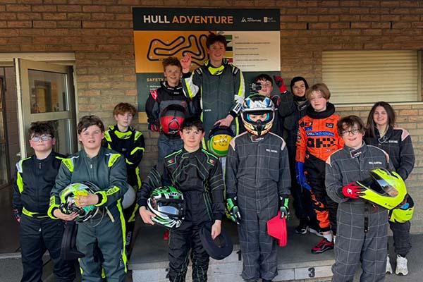 A photograph of junior karting competitors stood around the winners podium