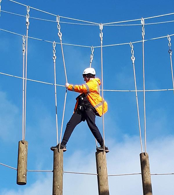 Person walking on a high ropes course